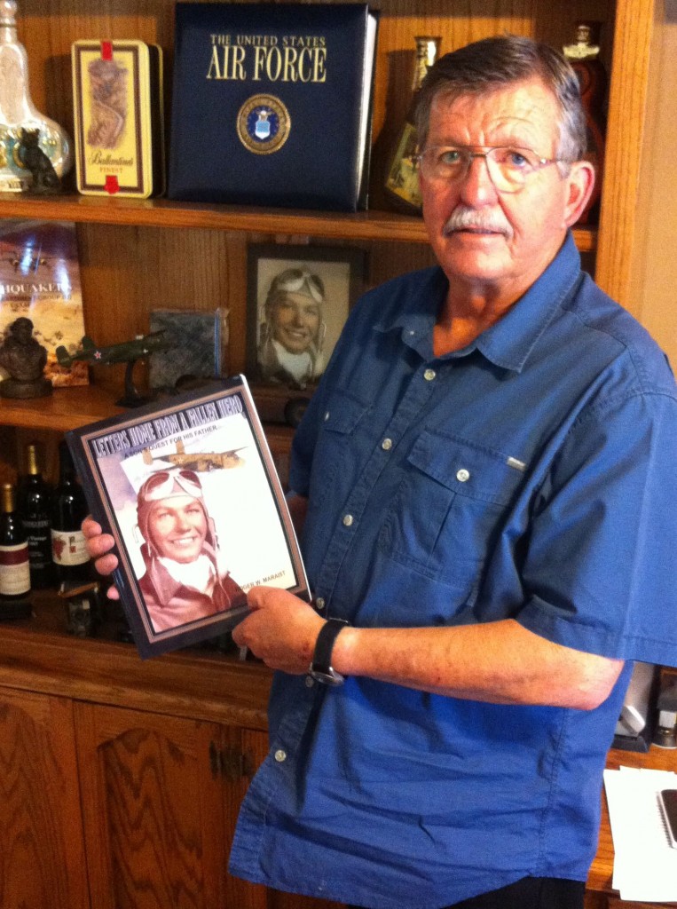 Roger Maraist holding a copy of his book.