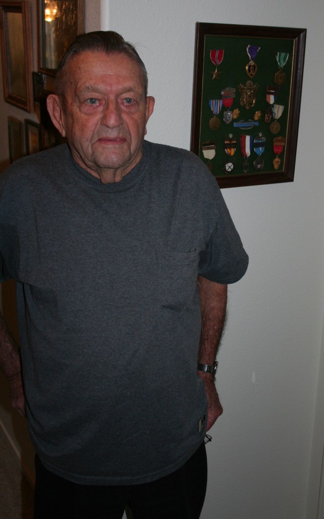 Don Fries in front of the medals he earned while serving in the 1st Infantry Division.