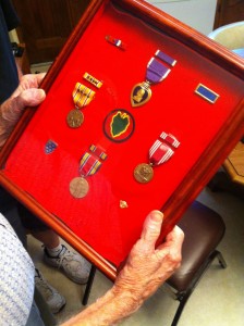 Dave Wall holds the medals he earned while serving with the 24th Infantry Division, including his Purple Heart.