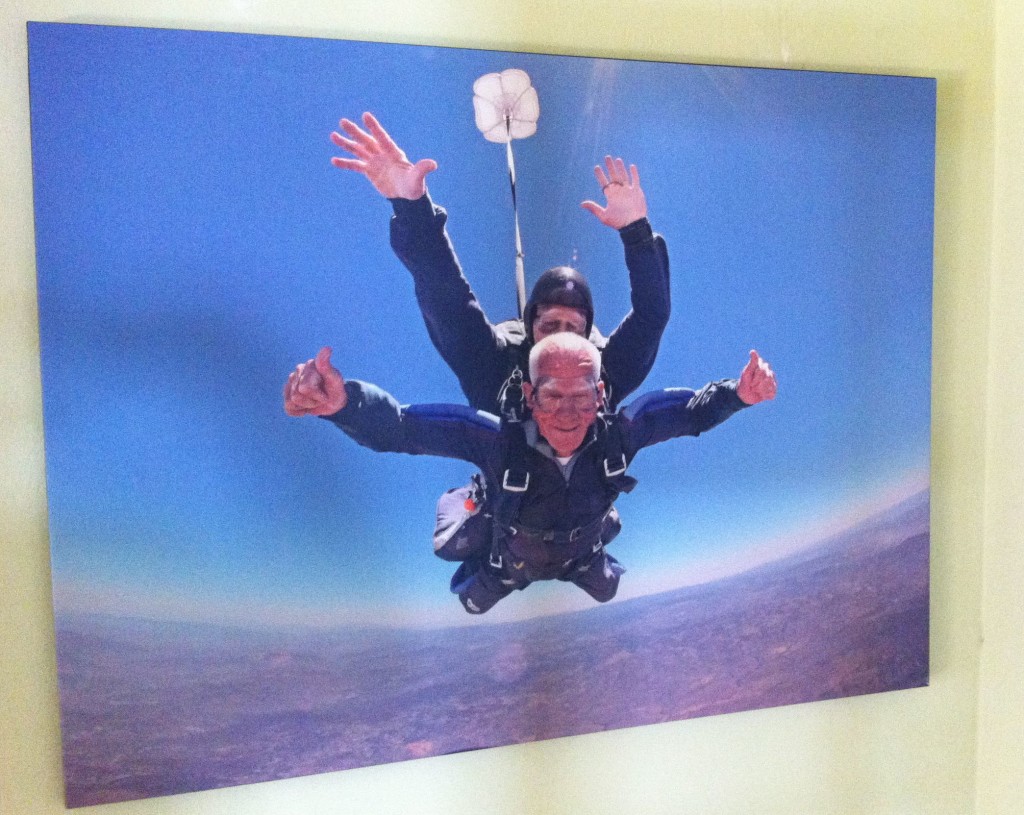 A giant print of a 92-year-old Tom Rice on a tandem skydiving jump on June 6, 2014 adorns the wall of his Coronado home.