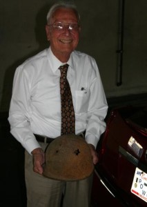Glenn Schmidt holding his helmet from WWII.