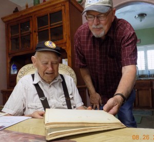 Orville Lewis and Les Beck look through the "Wartime Log" kept by Beck's father in Stalag XVII-B