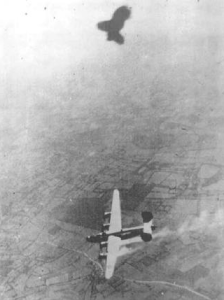 The tiny white dots visible at the bottom of this photo are Irwin and his crewmates escaping their damaged B-24.